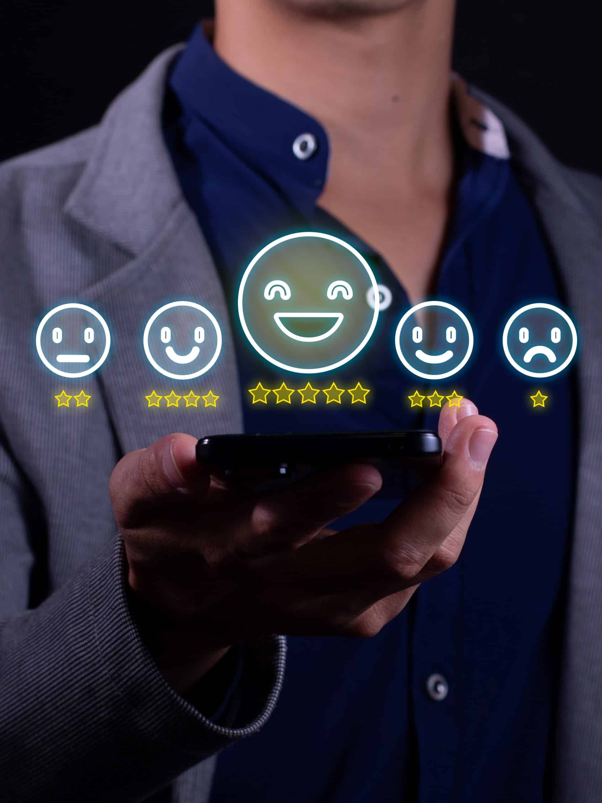Momentum Metrics employee holding a smartphone with digital smiley faces and star ratings, illustrating positive customer experience feedback