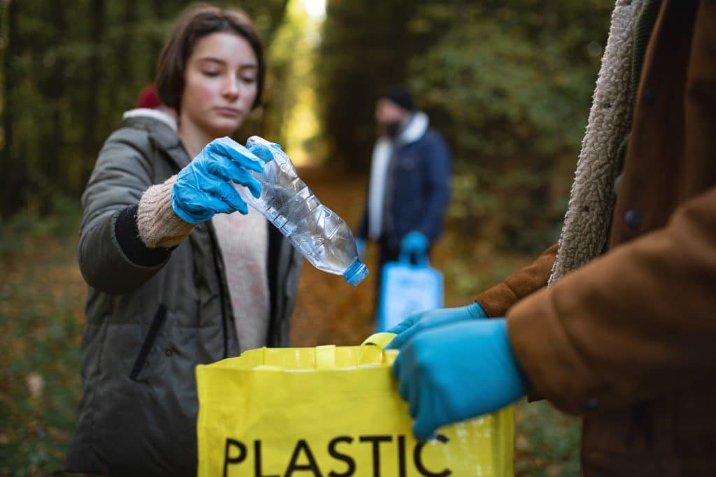 diverse group of volunteers cleaning up forest from waste, community service concept.