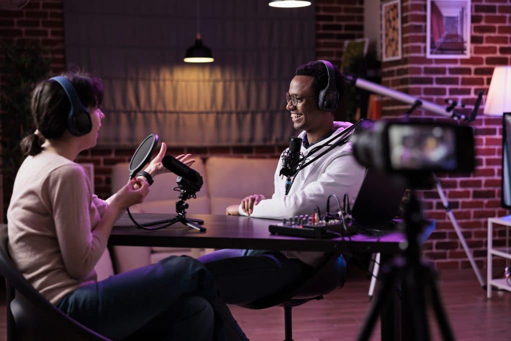 man and woman recording podcast conversation on camera